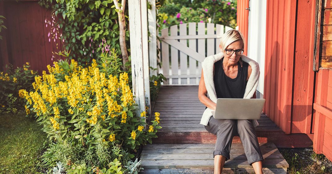 Woman using her laptop in the backyard