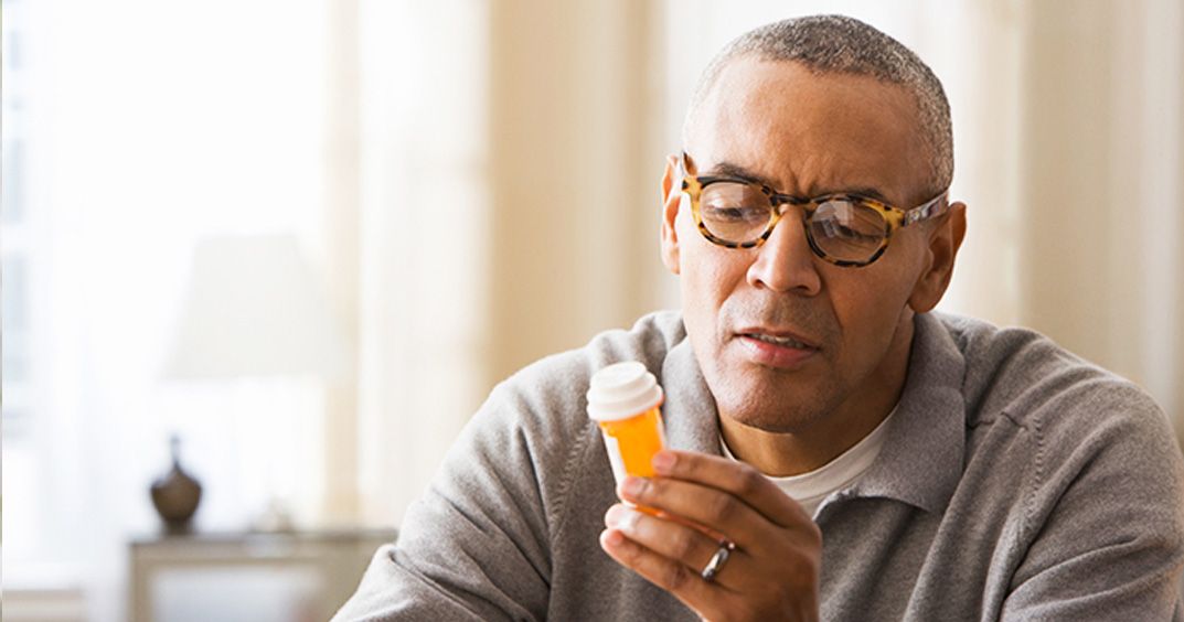 Men reading the label of his medicine