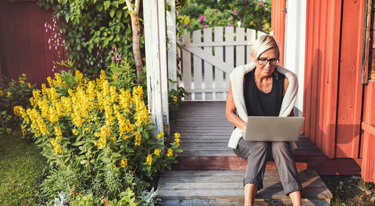 Woman using her laptop in the backyard